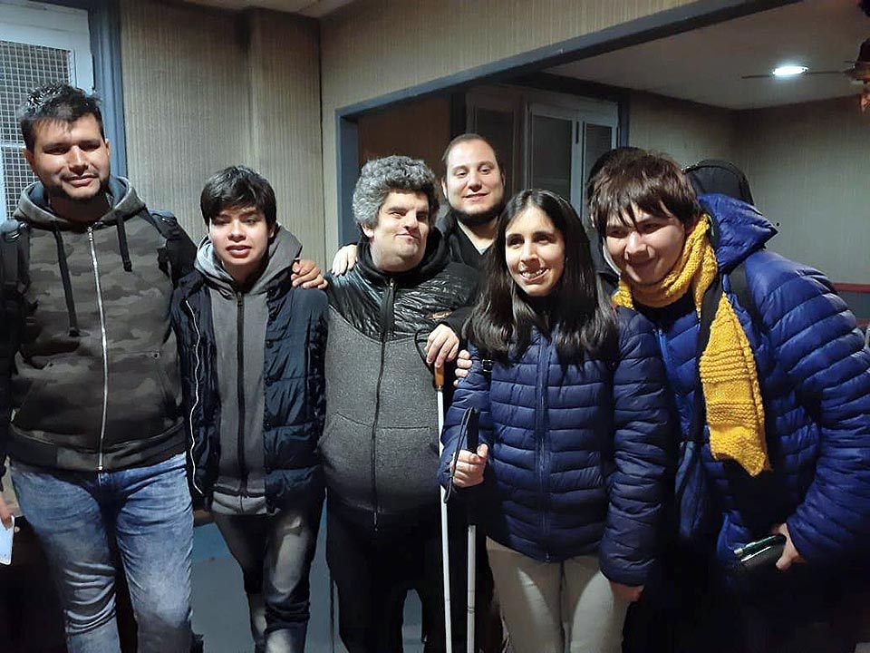 En la imagen se encuentra el grupo que participó de la actividad y los organizadores, posando para la foto en una sala de la Biblioteca Argentina para Ciegos.